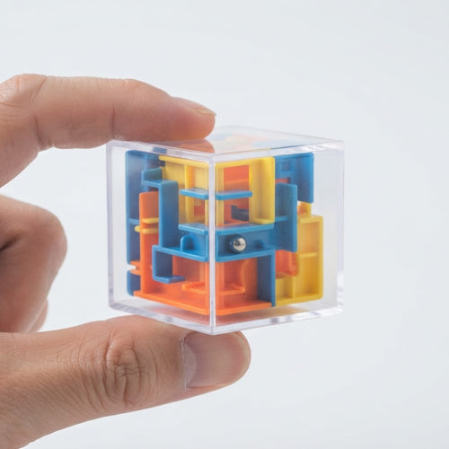 Fingers holding the small maze cube